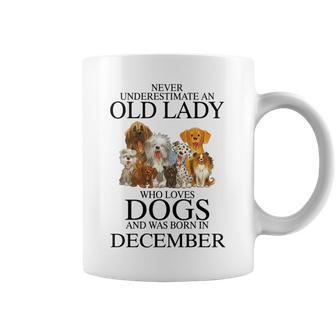 Never Underestimate An Old Lady Who Loves Dogs Born December Coffee Mug - Seseable