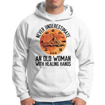 Never Underestimate An Old Woman With Healing Hands Old Woman Funny Gifts Hoodie | Mazezy