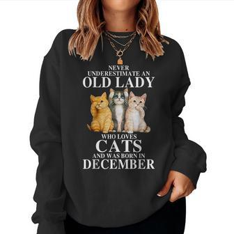 Never Underestimate An Old Lady Who Loves Cats Born December Women Sweatshirt | Mazezy