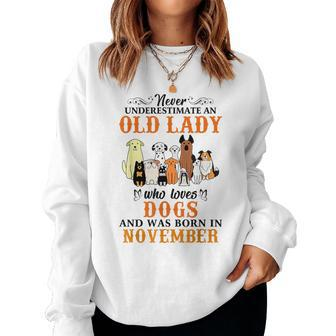 Never Underestimate An Old Lady Loves Dogs Born In November Women Crewneck Graphic Sweatshirt - Seseable