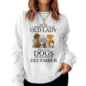 Never Underestimate An Old Lady Who Loves Dogs Born December Women Crewneck Graphic Sweatshirt - Seseable