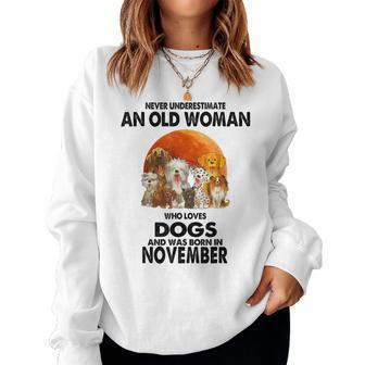 Never Underestimate An Old Woman Who Loves Dogs November Women Sweatshirt - Thegiftio UK