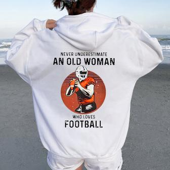 Never Underestimate An Old Woman Who Loves Football Women Oversized Hoodie Back Print - Monsterry CA
