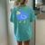 A Small Minimally Designed And Illustrated Blue Duck Women's Oversized Graphic Back Print Comfort T-shirt Chalky Mint