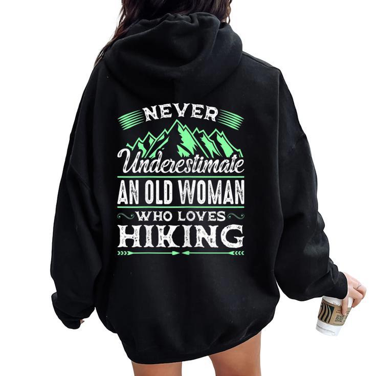 Never Underestimate An Old Woman Who Loves Hiking Women Oversized Hoodie Back Print